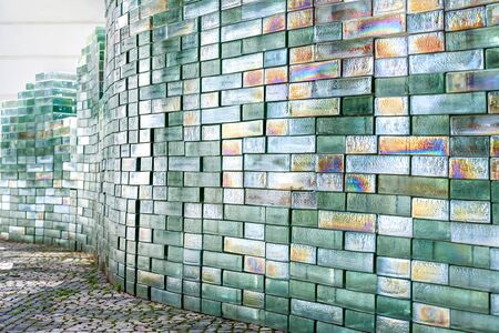 Outdoor construction of silver foil glass bricks. Mosaic texture, abstract geometric pattern. A colourful glass blocks wall background. Structured surface. Architecture, interior.の写真素材