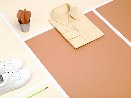 Minimalist still life with plain cotton shirt and sneakers. Neutral earthy colorus. Warm clay brown and cream colours office outfit. Top angle view, copy space.の写真素材