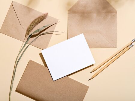 White empty paper card with stationery set of envelopes, notebook, pencil. Blank card styled mockup...