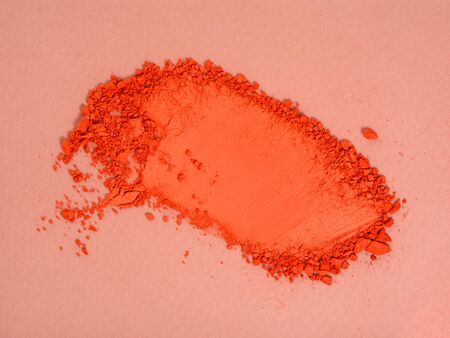 Top view of smudged red orange eyeshadow sample. Crushed or broken cosmetics product. Makeup and cosmetics background.の写真素材
