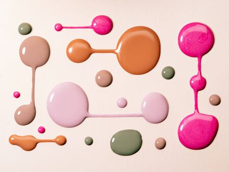 Nail polish rounded swatches on neutral beige background. Closeup of paint spills. Creative composition of various nail polish drops for manicure.の写真素材