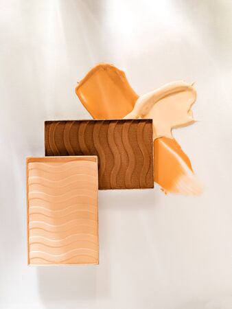 Still life of beauty products with soft light and shadows. Composition of smudged and scattered makeup texture. Closeup of nude makeup products for makeup artists.の写真素材