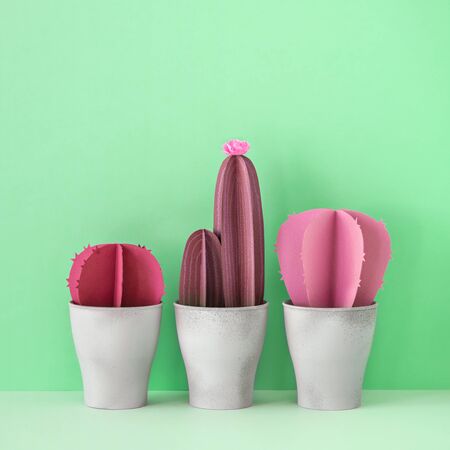 Creative three-dimensional paper cactuses on vivid green background. Pots with pretty fake succulent plants for office design. Exotic summer concept. Side view, copy space.の写真素材