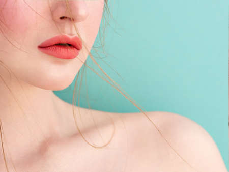Close Up face detail. Perfect natural lip makeup and healthy skin. Beautiful female face and delicate shoulder in soft daylight. End of summer and seashore mood.の写真素材