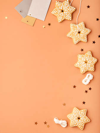 Simple Christmas or New Year background with gingerbread cookies shaped as a snowflakes, star confetti and blank gift tags. Copy space for text. Christmas, New Year and winter holidays concept.の写真素材