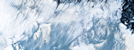 Close-up fragment of smudged paint texture with marble pattern. Moody liquid paint background. Monochromatic abstract art wallpaper.の写真素材