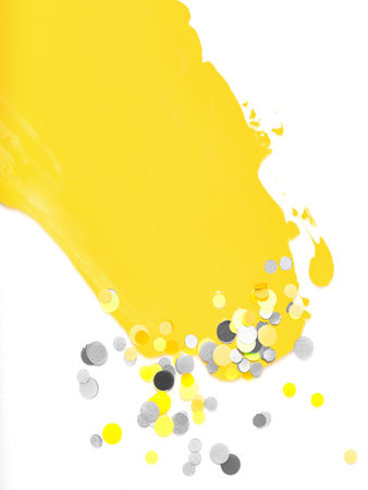 Brushstroke of illuminating yellow paint and ultimate gray confetti isolated on white background. Creative background toned in main color of the year 2021. Copy space for text.の写真素材