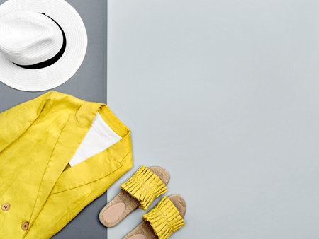 Female jacket and stylish slippers in trendy illuminating yellow colour on contrast ultimate gray background. Minimalist female outfit. Color of the year 2021. Main color trend. Summer sale concept.の写真素材