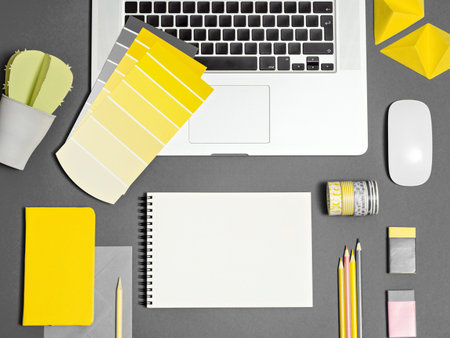 Home office for freelance girl. Bloggers workplace with illuminating yellow color samples, blank note, office supplies on ultimate gray backdrop. Mockup for text, sketch. Main colour of the year 2021の写真素材