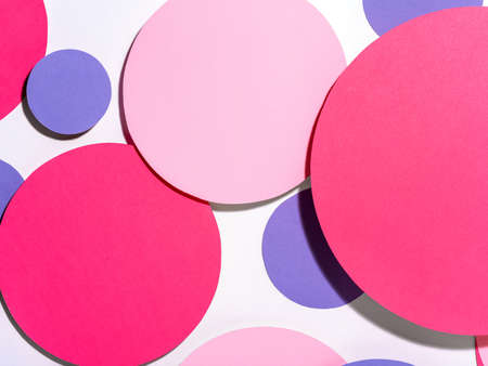 Background of colorful paper circles in memphis geometric style. Cut out pink and purple circles styled layout with hard light and shadows. Vivid abstract background or template.の写真素材