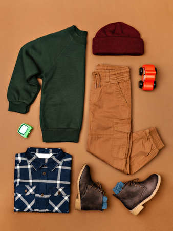 Composition of toddler boy warm clothes, shoes and a toy on colorful background. Set of childrens clothes for autumn. Kids fashion outfit. Winter, autumn collection. Organic cotton. Top view, flat layの写真素材
