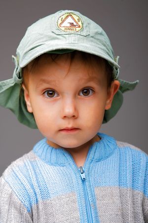 Closeup portrait of a little boy in a cap, serious attentive lookの写真素材