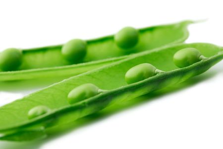  A close-up of a pea pod split open revealing peas on white backgroundの写真素材