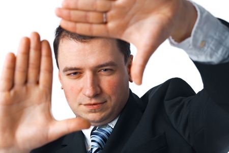 Close up portrait of a confident young busnessman making a frame shape with his hands over white background の写真素材