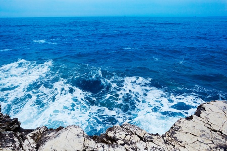 The waves breaks on the stony beach with splash and foam.の写真素材