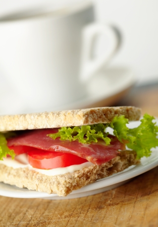 Homemade sandwich with bacon, tomato, rukola and mayonnaise on whole-grain breadの写真素材