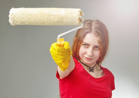 girl holds a roller for painting