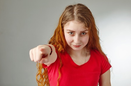 The beautiful redhead girl, pointing finger at camera.の写真素材