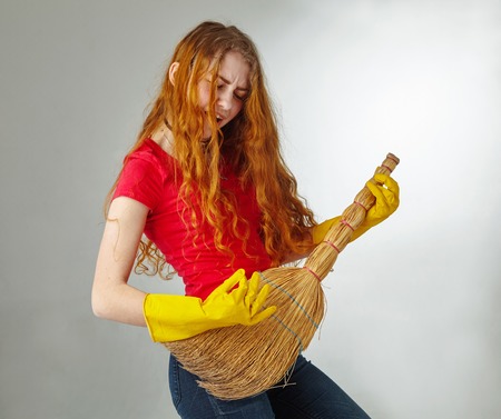 Cheerful housewife playing on her guitar broom.の写真素材