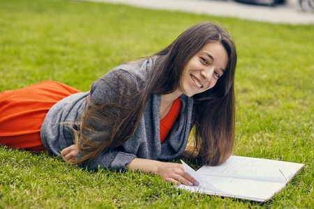 Beautiful woman reading book in natureの写真素材