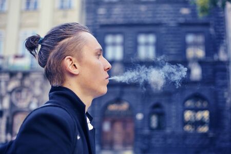 young handsome hipster man smoking cigaretteの写真素材