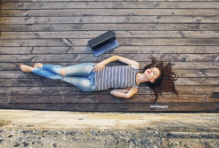 girl relaxing on a wooden floor . Relax, rest, education concept, recreation .の写真素材