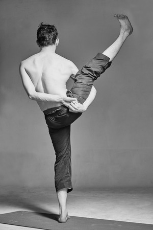 young man is engaged in yoga in a studioの写真素材