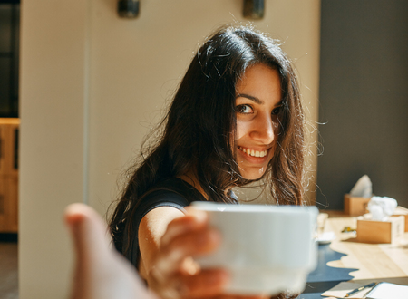 a happy young woman, offers you coffeeの写真素材