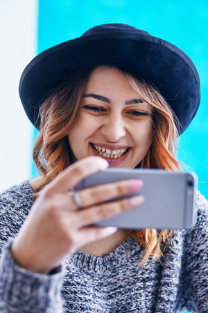 a young beautiful girl communicating through a smartphoneの写真素材