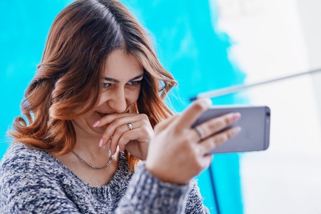 a young beautiful girl communicating through a smartphoneの写真素材