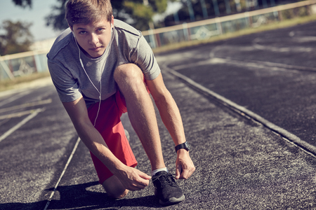 man lacing sport shoes for preparing for training at sunriseの写真素材