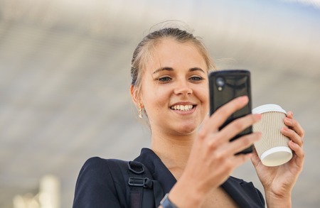 a beautiful young woman is using an app in her smartphone device to send a text message