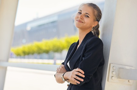 Portrait of a businesswoman standing in front of windows an office building