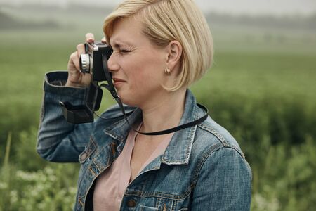 Tourist girl photographing a vintage retro camera.