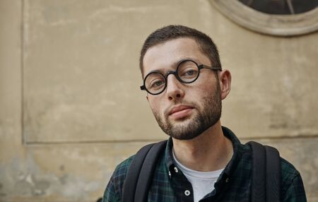 Portrait of beautiful young man in classic round glasses
