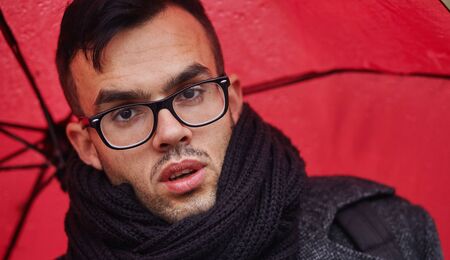 businessman goes in the rain with red umbrellaの写真素材