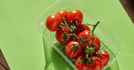 Colorful red tomatos on green background. From top view.の写真素材
