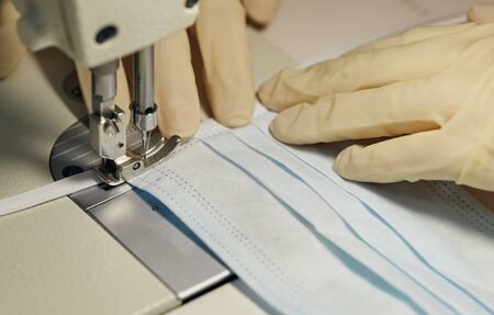 work process of sewing masks for protection against coronavirus