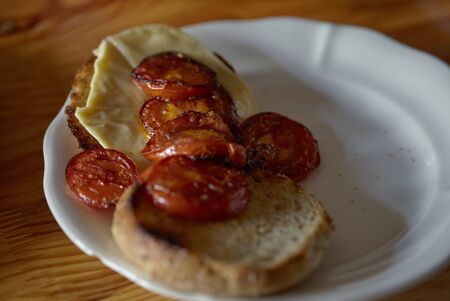 sandwich on toasted crust of bread with cheese and toasted tomatoes.の写真素材