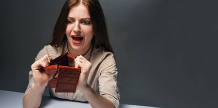 Young woman shows her empty wallet. Bankruptcy conceptの写真素材