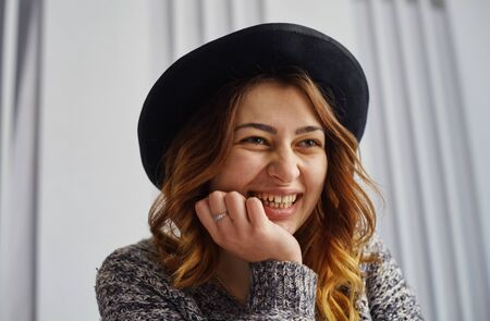 Portrait of a happy casual businesswoman in sweater sitting at her workplace in officeの写真素材