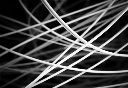 Intricate patterns of white lines converge and diverge in an abstract presentation against a dark background, showcasing the beauty of geometric simplicityの素材