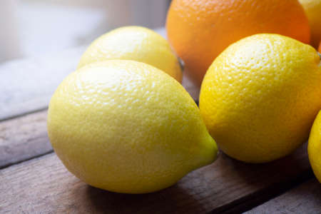 Close up lemons and oranges on old wooden table. Rustic, loft style.The concept of healthy eating, cooking healthy food,fruits with vitamin Cの写真素材