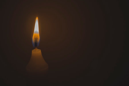 Close up white lighted candle in the dark. Memory of the dead. Background for church theme, prayers with copy spaceの写真素材