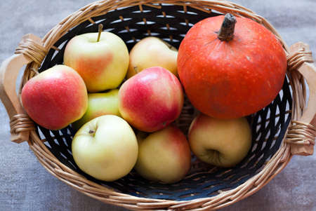 Pumpkin and apples in a basketの写真素材