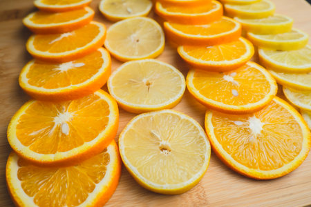 Slices of lemons and oranges on a wooden board. Close-up  image of fruitの写真素材
