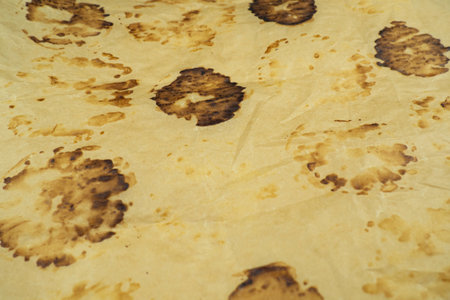 Texture of brown round traces on crumpled parchment. Traces of burnt pastriesの写真素材