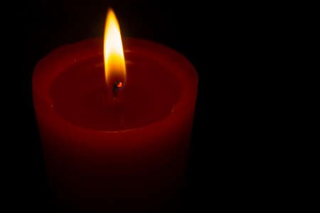 Top view red lighted candle on a black backgroundの写真素材