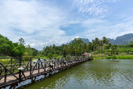 Wooden bridge over the river of the park with blue sky background in rural Thailandの写真素材