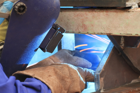 welder is welding steel structure with all safety equipment